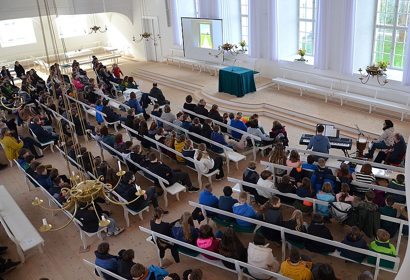 Schülerinnen und Schüler sowie Lehrerinnen und Lehrer im Kirchensaal